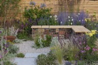 A sustainable, low maintenance gravel garden filled with drought tolerant plants to attract pollinators, such as salvia, achillea, sea pinks, echinops, fleabane, perovskia, gaura, drumstick allium and catmint. Turfed Out Garden. Design: Hamzah-Adam Desai.