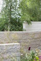 The Mind Garden. Designer: Andy Sturgeon. Sculptural walls dividing areas of the garden with soft mixed planting. RHS Chelsea Flower Show 2022. Gold Medal.