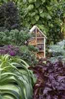 Bug house among kale, beans and leeks  - BBC Gardeners' World Live, Birmingham June 2022 - 'Marshalls Food for Thought Garden' - designer Jon Wheatley