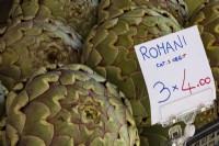 Romanesco globe artichokes, marketed locally as 'Romani', on market stall in Italy.