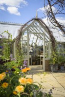 Alitex National Trust Collection Greenhouse in Wood Sage, entrance framed by Sweet Peas in large pots and Calendula - marigold flowers at RHS Hampton Court Palace Garden Festival 2022 