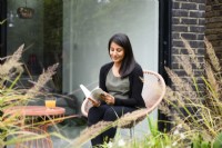 Meera, the owner reading a book in the garden. 