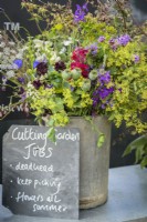Cottage garden flowers in a vase with memo chalkboard with cutting garden jobs info at RHS Hampton Court Palace Garden Festival 2022 