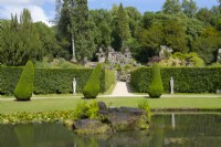 A fountain set on rocks in the Ring Pond in front of Paxton's Rock Garden, Chatsworth House and Garden.