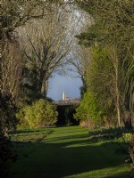 View of Happisburgh church from the Apple walk East Ruston Old Vicarage gardens Norfolk March Spring