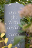 Slate with text in a country garden.