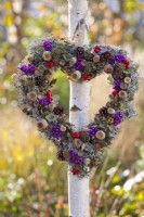 Heart shaped wreath made from cones, poppy seedheads, rowan and Callicarpa berries, lichens and acorns.