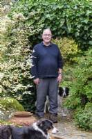 Man with two dogs in his garden.