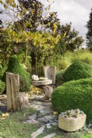 Rustic timber seats framed by clipped box at John Massey's garden in October.