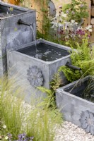 Contemporary garden design with water spout, summer July