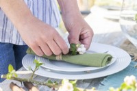 Woman laying table decorations in greenhouse