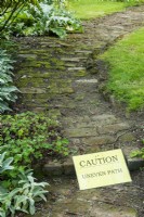Warning sign on uneven brick path - Open Gardens Day, East Bergholt, Suffolk
