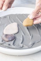 Woman placing stones in a pattern on the grout