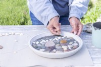 Woman placing stones in a pattern on the grout