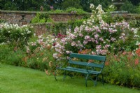 Painted seat against deep border of Roses and Alstroemerias - Peruvian Lillies, in walled garden - Helmingham Hall, Suffolk