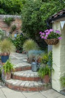 Courtyard patio with steps to lower level, container planting and  hanging basket - Open Gardens Day, Coddenham, Suffolk