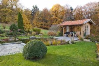 Summer house with seating area by the pond.