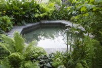 An octagonal pool is edged in shade-loving ferns and herbaceous perennials.