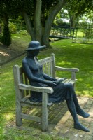 Metal statue of lady reading a book seated in shaded area of the garden - Garden Festival Day, Fressingfield, Suffolk