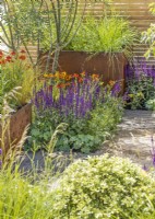 Terrace garden with small bed and plant containers, summer July 