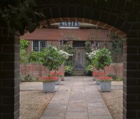  Entrance Court at East Ruston Old Vicarage Gardens, Norfolk July Summer.  Formal arrangement of square planters at intersection of paved paths 