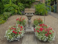 Entrance Court at East Ruston Old Vicarage Gardens, Norfolk July Summer. Formal arrangement of planters around a centrally-placed bird bath