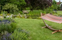 Garden hammock on lawn with pool and seat beyond - Open Gardens Day, Worlingworth, Suffolk