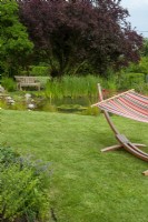 Garden hammock on lawn with pool and seat beyond - Open Gardens Day, Worlingworth, Suffolk