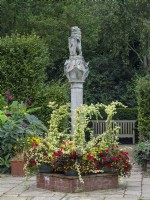 The Scottish Sundial and metal containers with mixed bedding plants  Old Vicarage Gardens  East Ruston Norfolk Early October