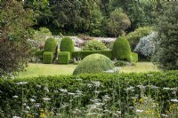 View across the garden at Moor Wood, Gloucestershire, with roses and clipped hedges
