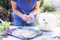 Woman painting glue onto a pressed Viola