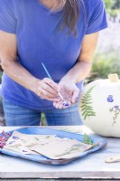 Woman painting glue onto a pressed Viola