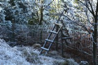 A nook with a ladder in the mountains covered with hard rime.