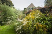 Border of prairie planting with house in the distance. Stipa pseudoichu and various Rudbeckia