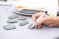 Writing names on flat stones to use as place labels