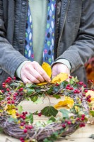 Woman securing Beech sprigs to the wreath