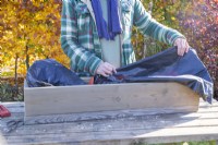 Woman placing compost bag as liner in the window box