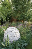 Stone cairns sit amongst the herbaceous planting including Acanthus 'Rue Ledan' in Horatio's Garden - Designer: Charlotte Harris and Hugo Bugg  -Sponsor: Project Giving Back -