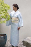 Portrait of garden designer Mika Misawa in a kimono standing next to an Acer tree at RHS Chelsea flower Show September 2021