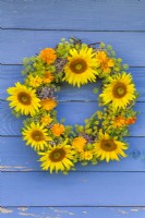 Summer flower wreath made of sunflowers, pot marigold, fennel and Eupatorium.