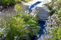 A modern contemporary water rill with mixed perennial planting of Euphorbia, Geranium pratense 'Mrs Kendall Clark' and Lychnis flos-cuculi 'White Robin' 