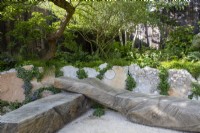 Oak bench seat - reclaimed concrete raised beds with mixed perennial planting - Carex remota, Epimedium perralchicum 'Frohnleiten', Fatsia japonica, Astrantia 'Buckland' and ferns 