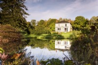 Regency House, Devon in October, reflected in a pond in front of the farmhouse