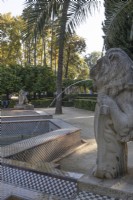 A colourful, tiled, geometric pool with lion statues spouting water into pool. Parque de Maria Luisa, Seville, Spain. September