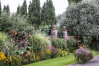 The swimming pool garden borders are planted with hot colours at The Manor, Little Compton.