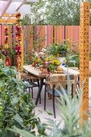 View of dining area decorated in Indian style with colourful flowers, fruits and spices.The RHS and Eastern Eye Garden of Unity, Designer: Manoj Malde