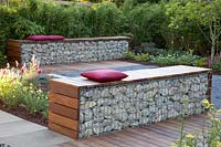 Gabion as a seating area in front of a bamboo hedge 