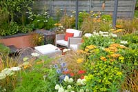 Seating area in the sunken garden with perennials, Achillea Terracotta, Anemanthele lessoniana, Allium caeruleum Azureum, Euphorbia walichii, Eryngium Saphire Blue, Trifolium ochroleucum 