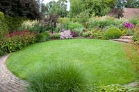 Lawn circle with bed, Sedum Purple Emperor, Artemisia, Saponaria lempergii Max Frei, Persicaria amplexicaulis Border Beauty, Veronicastrum, Sedum Abbeydore, Pennisetum alopecuroides 