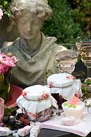 Still life with rose candies, rose jam, rose liqueur, rose marmalade, rose sugar 